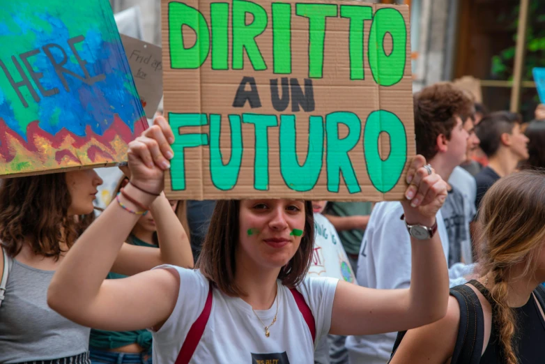 a girl holding a sign and an item up in the air