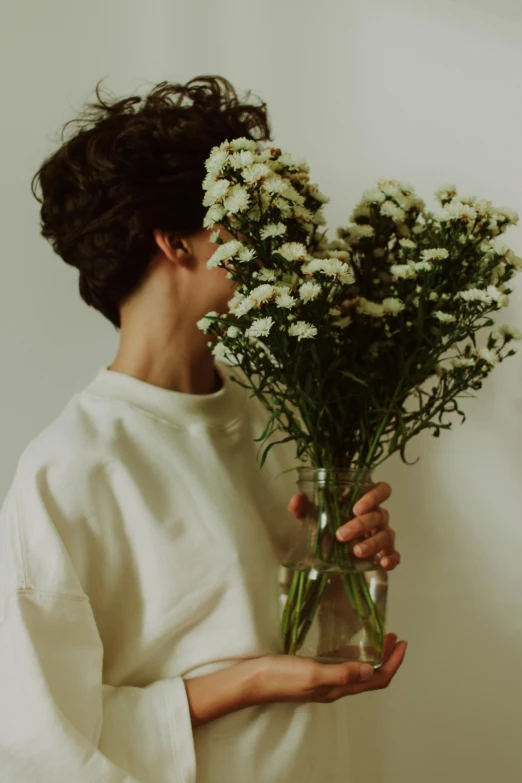 a woman holding a vase of flowers and smiling