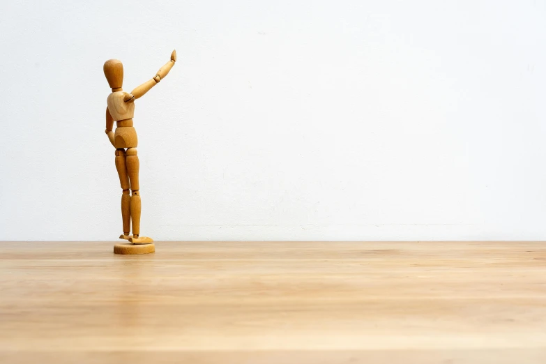 a figurine in the shape of a woman on a wooden floor