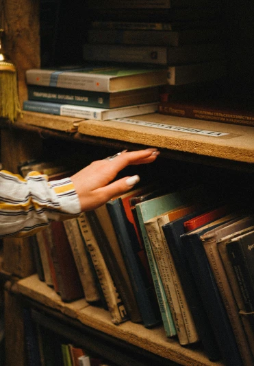 a person that is reaching for some books