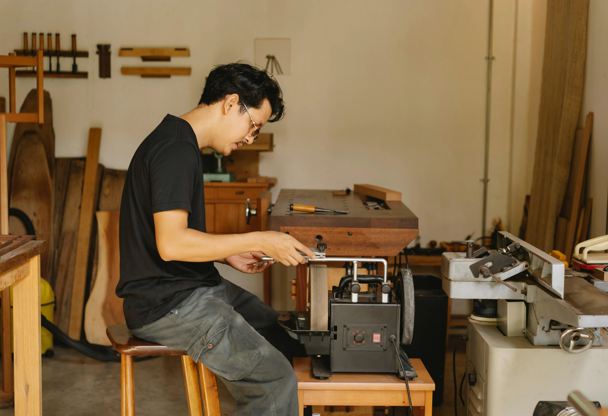 a man sitting in a chair next to a machine in a shop