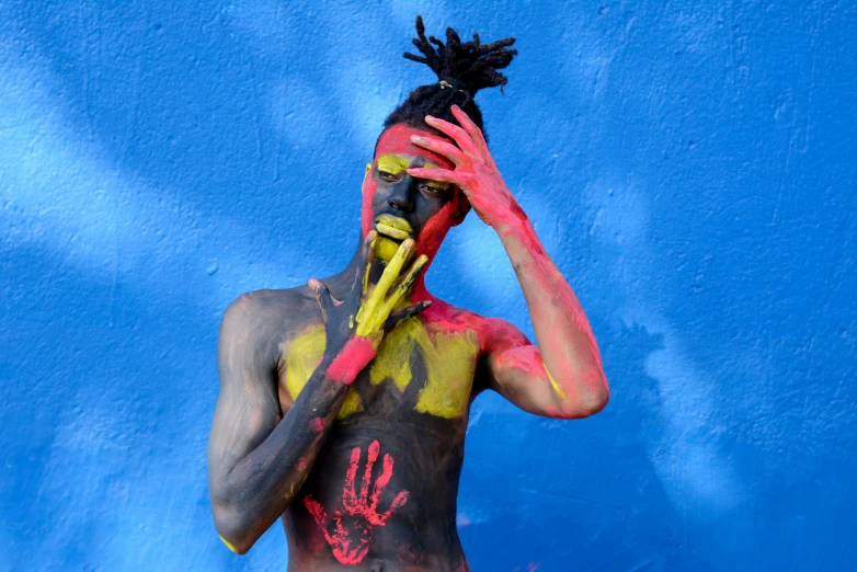 a man with painted face and body is standing