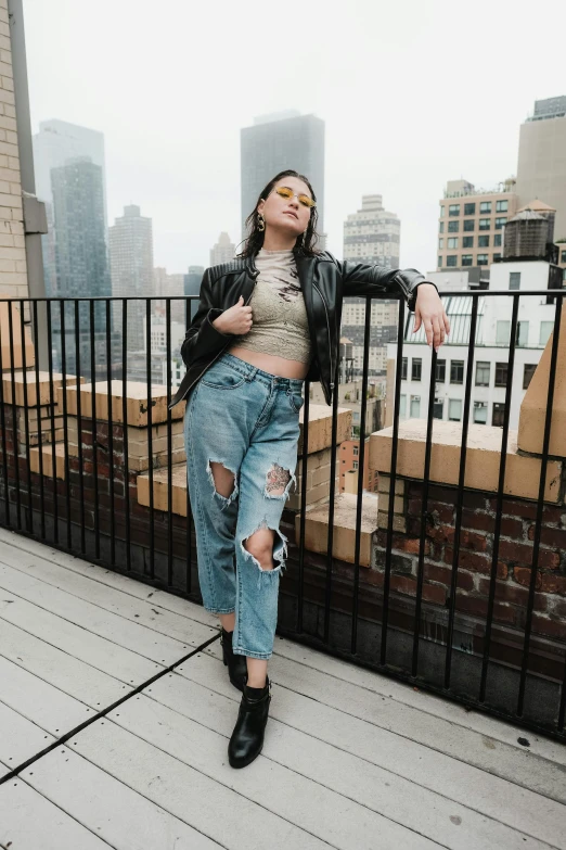 woman standing on deck near railing looking off into city