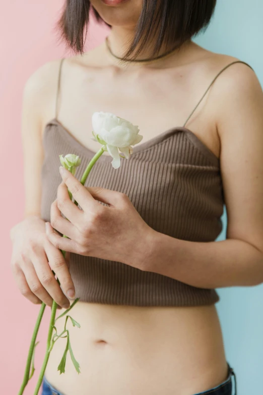 a woman in the image holding a white flower