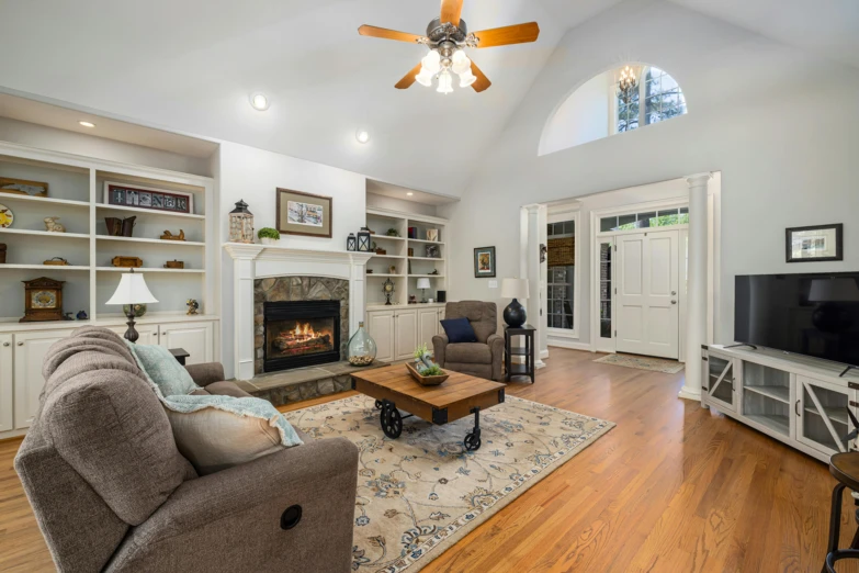 a large living room has a high ceiling and hardwood flooring