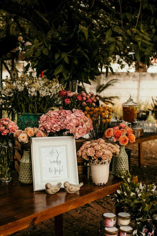 flowers and vases on top of a wooden table