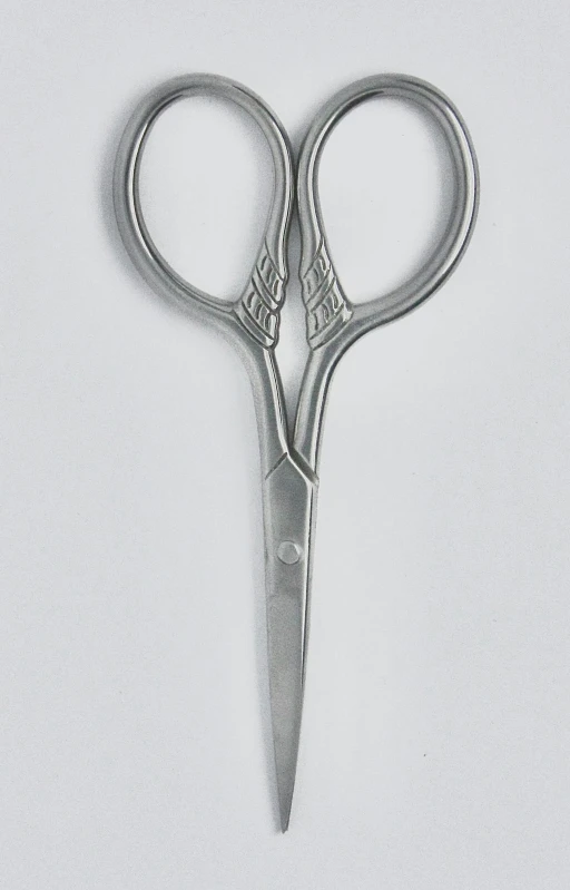 a pair of silver scissors lying on a white background