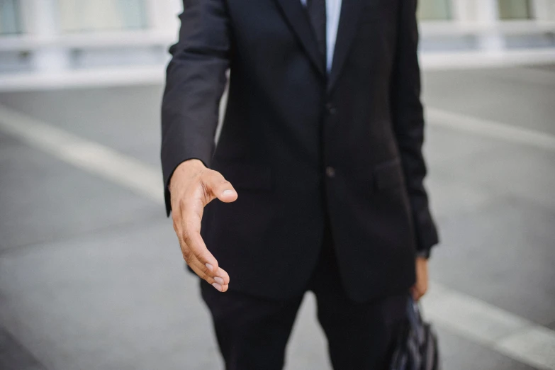 a man in a suit holds his hand out