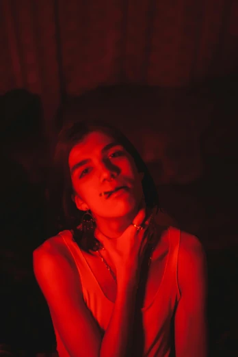 a woman sitting in the dark wearing red