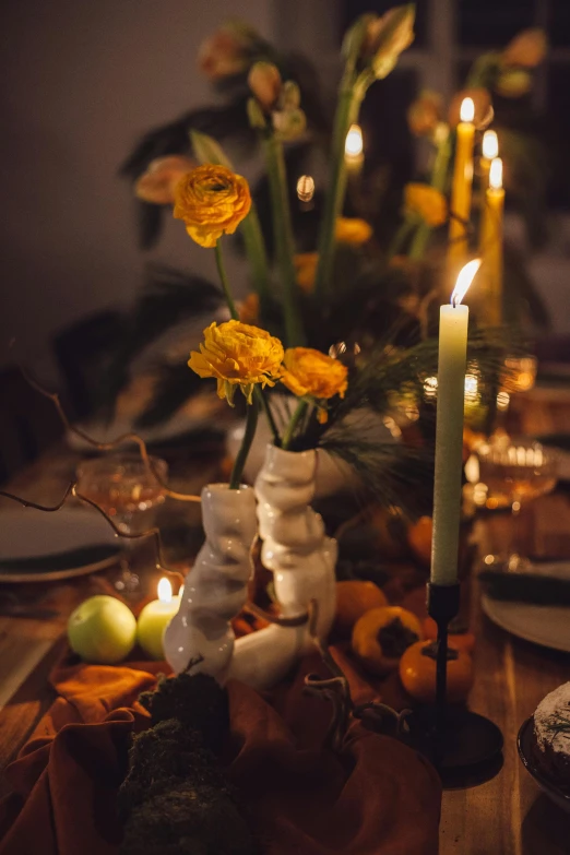 a group of yellow flowers are in a white vase on a wooden table