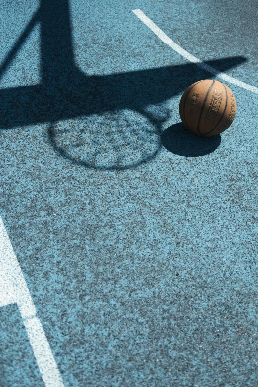 a basketball is sitting on the floor of an empty court