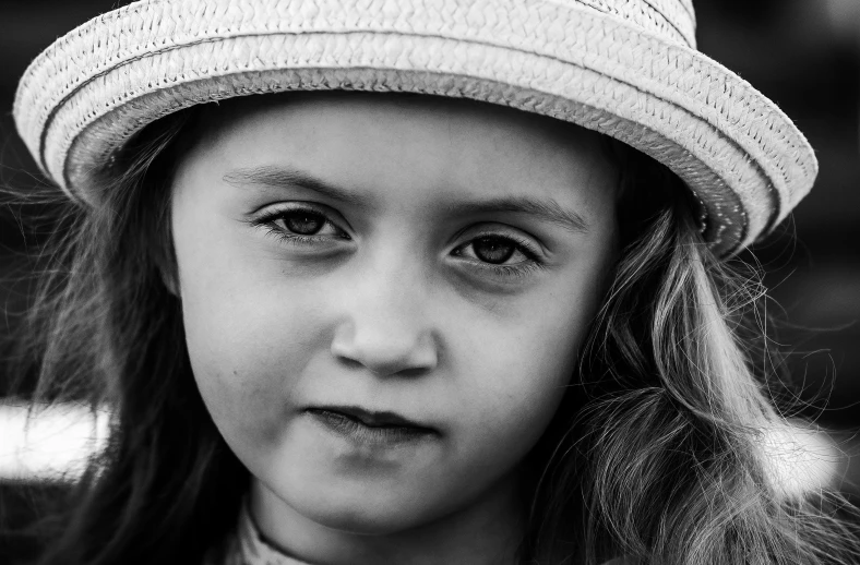 the little girl is wearing a hat and posing for the camera