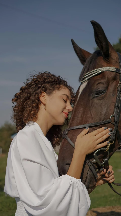a woman holds a horse that is touching her nose