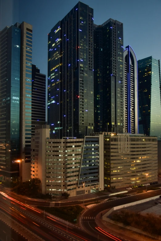 an empty freeway at night in a city with tall skyscrs