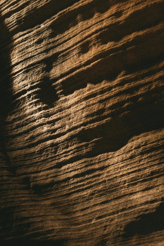 the top part of a surfboard in dark waves of sand