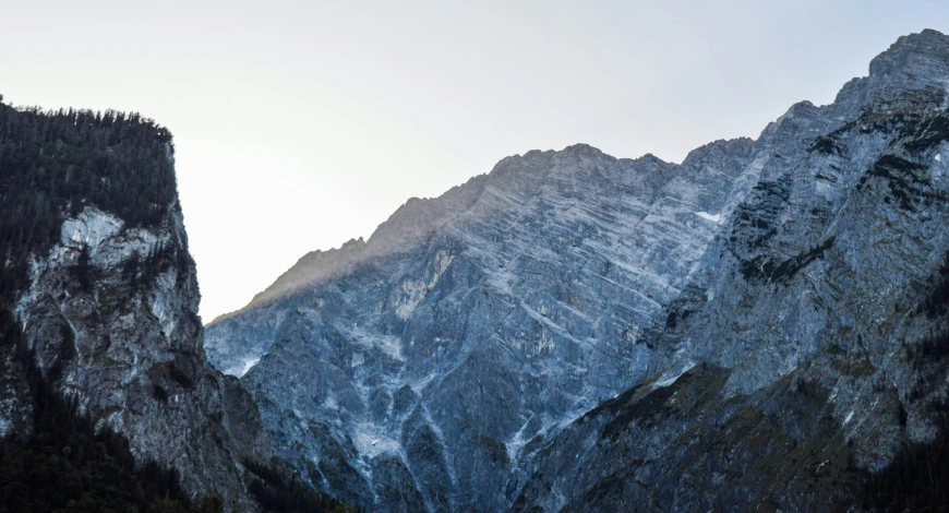 a large rocky mountain covered in snow and pine