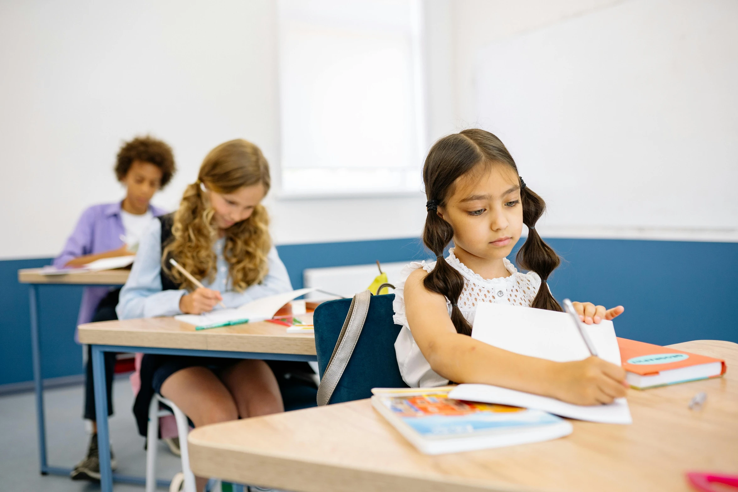 two s sitting at desks writing