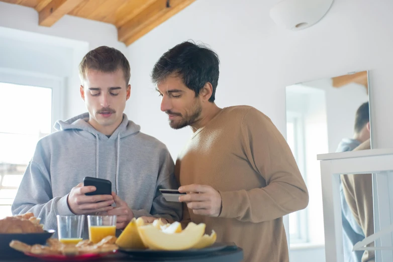 two men looking at a phone together