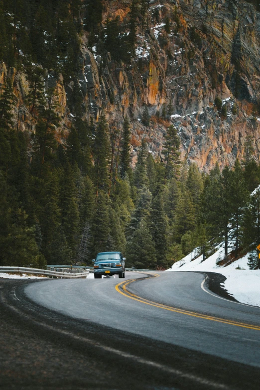 the car is driving down a winding mountain road