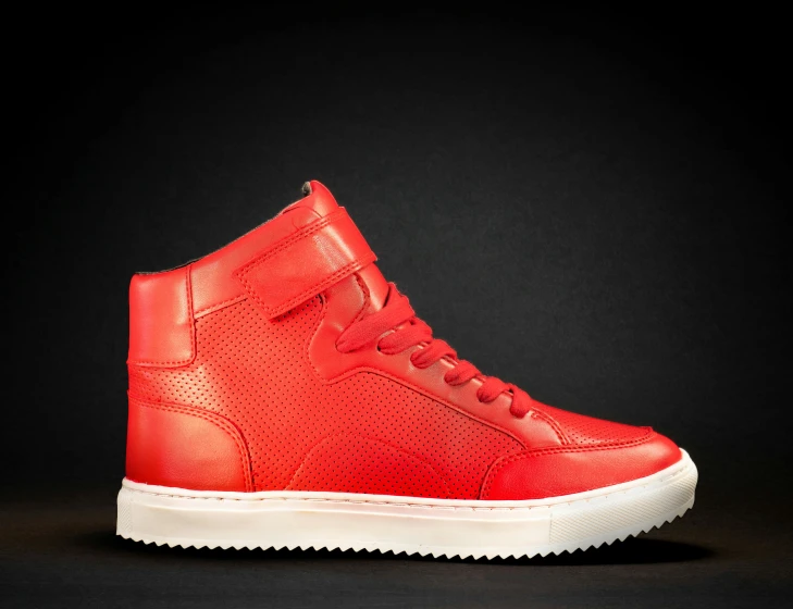 a red high top shoe with white soles on a black background