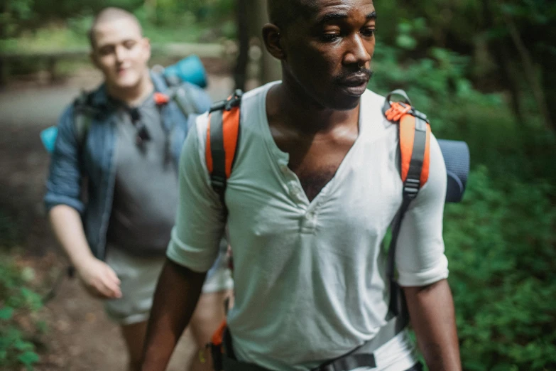 two men on hiking trekking through the woods