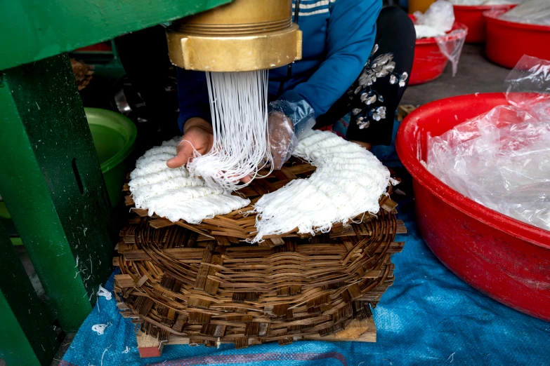 an old woven basket being cleaned by a woman