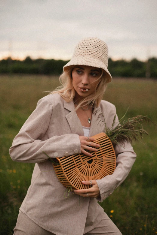 a woman wearing a beige hat with some grass