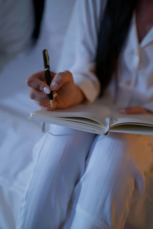 a person with a pen in their hand reading a book