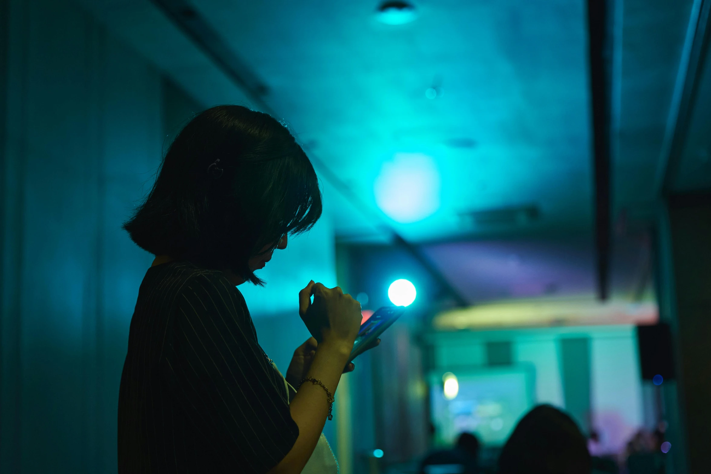 a woman texting at night with headphones on her