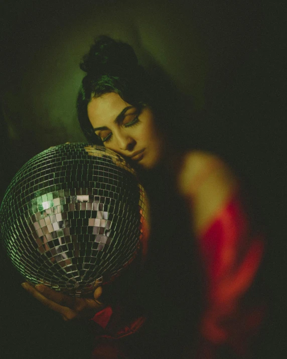 woman in dark room holding a disco ball
