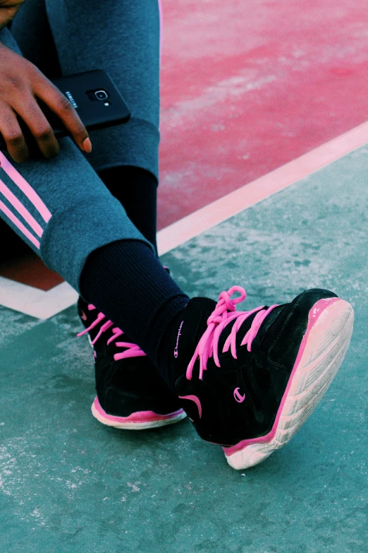 a person in black and pink shoes crouching down