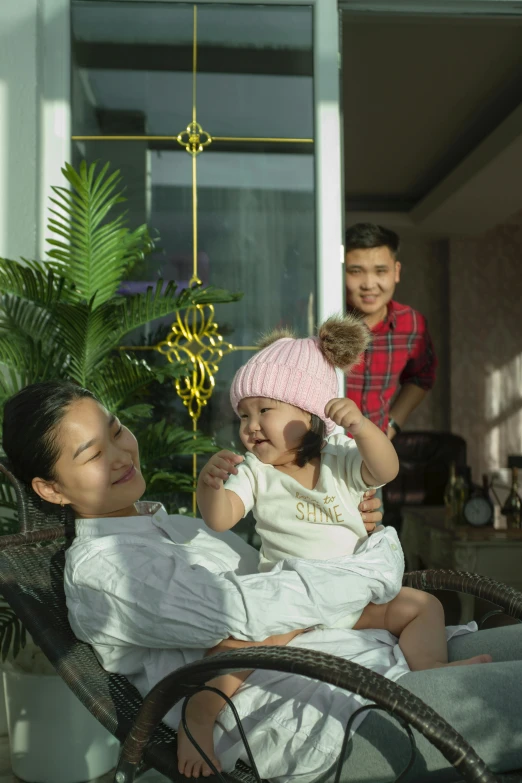 two adults and a child sitting on a couch near a plant