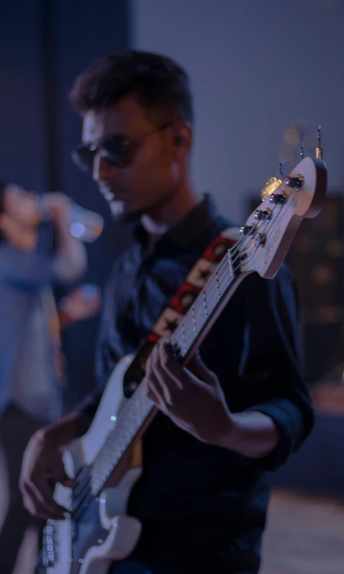 a young man is playing a white guitar