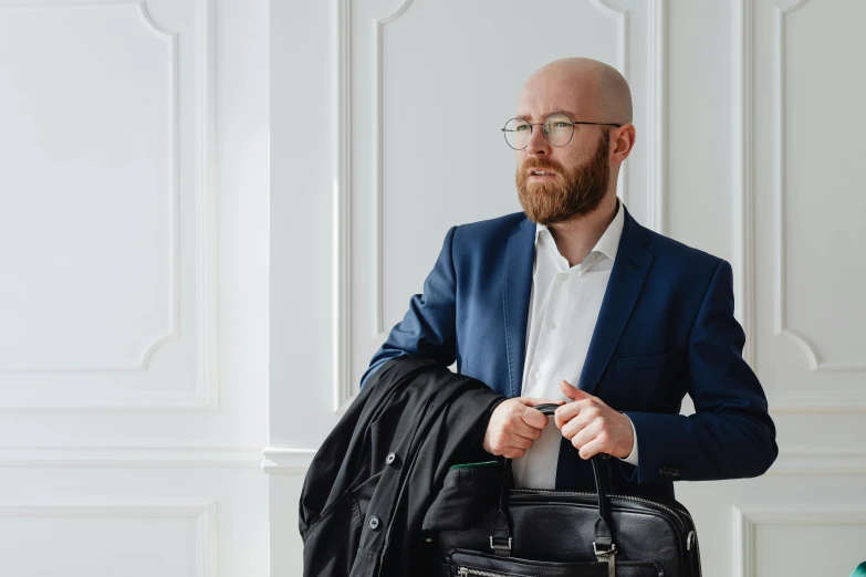 a bald man holding onto a black handbag