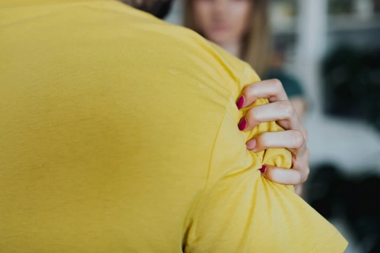 a woman adjusting a knot on a yellow top