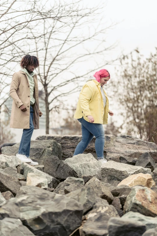 two people in the rocks near some trees