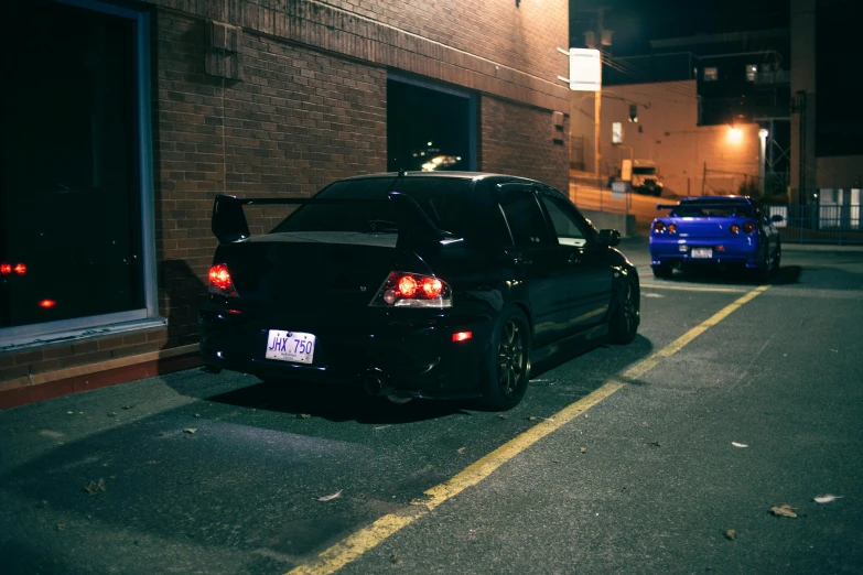 two cars parked on a street at night