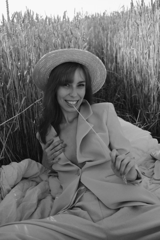 a woman in hat is laying on the grass