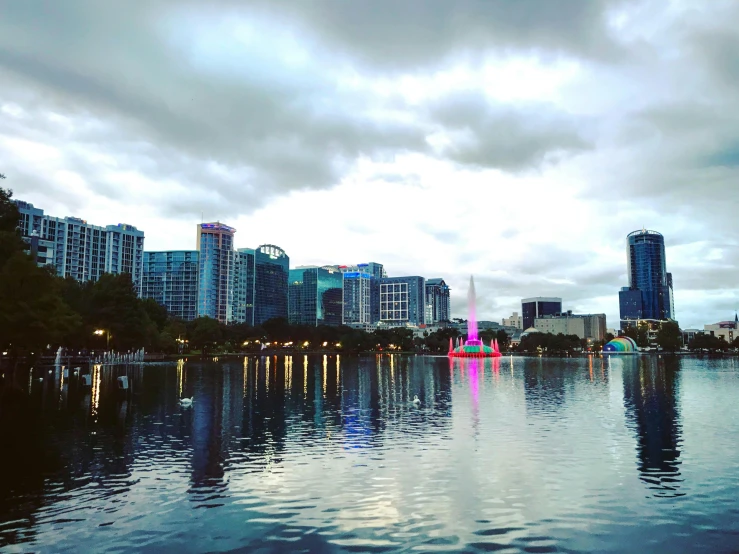 the sky is very cloudy and blue with the lights shining in the water