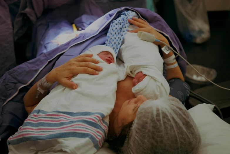 an infant and its mother sleeping on top of a bag