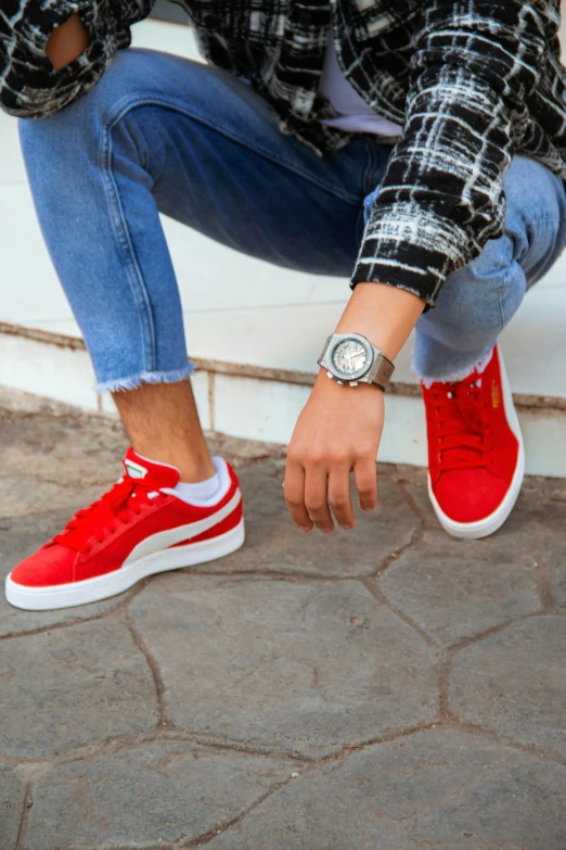 a man is sitting down with his red shoes