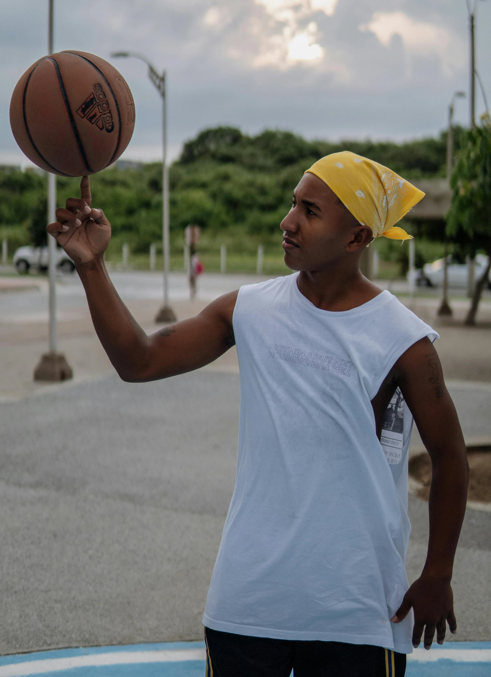 a man in yellow bandanna and white shirt with basketball