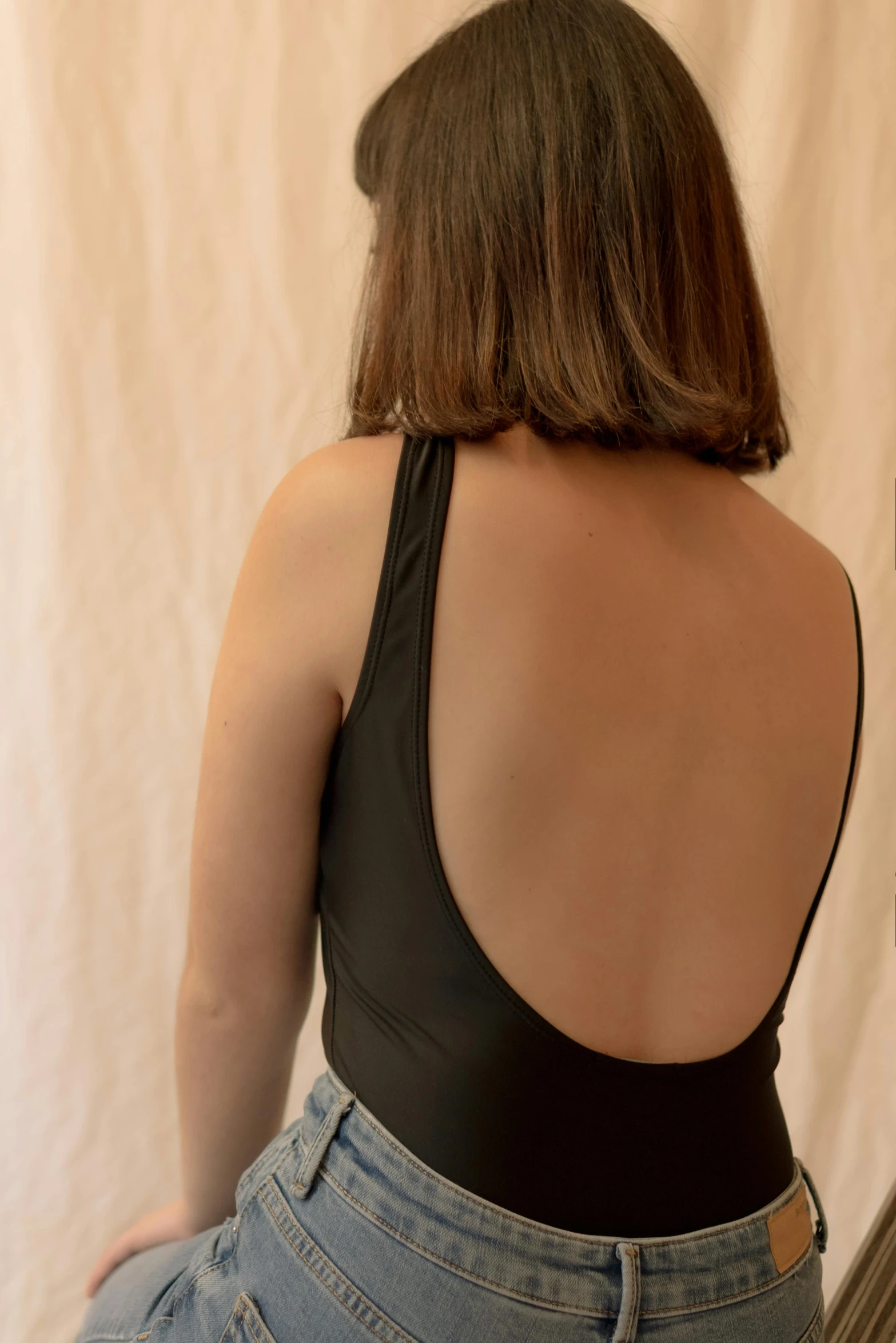 woman in black tank top and blue jeans