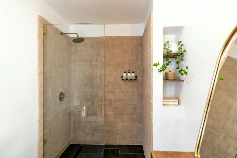 the bathroom has brown tiles and a stand - up shower