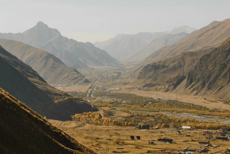 the view looking down onto a small village, road, and mountains