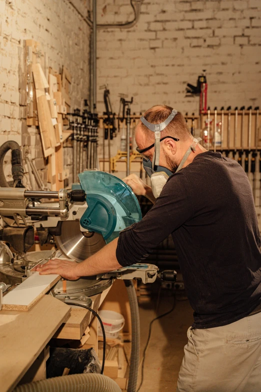 a man in front of a wooden machinery making a glass vase