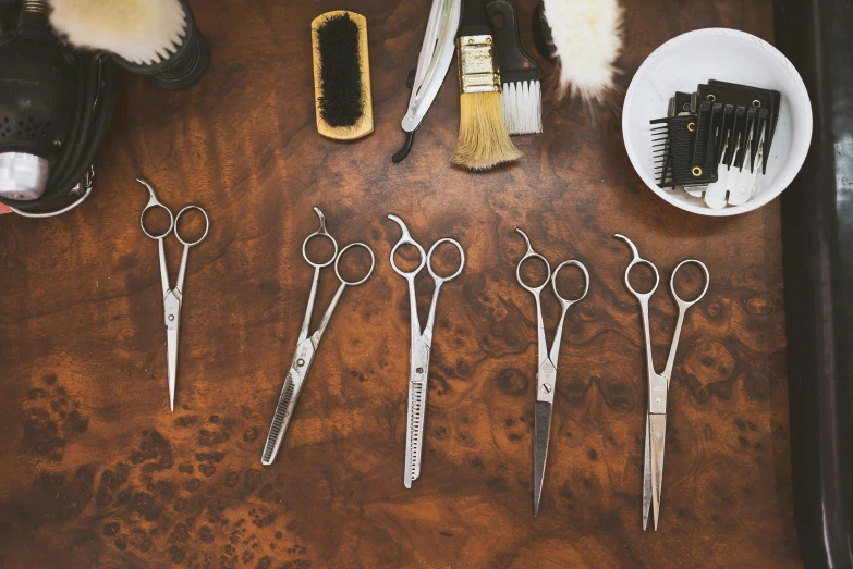 several pairs of scissors sitting on top of a brown table