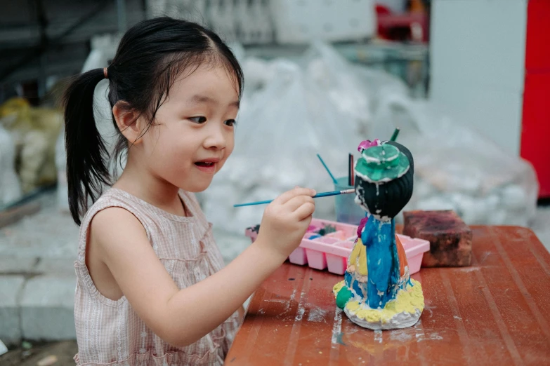 a little girl playing with a model dinosaur