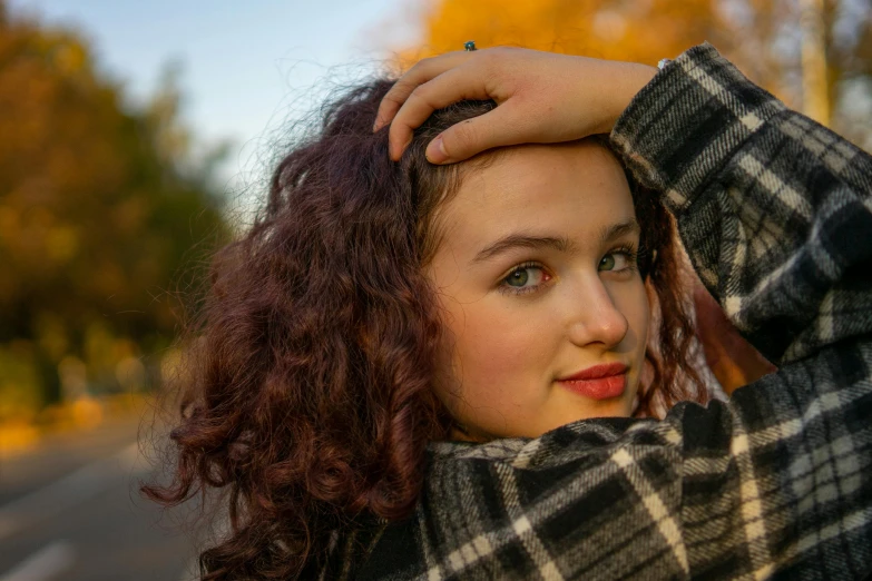 a  wearing a plaid jacket is holding her head