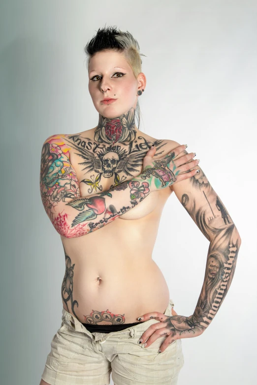 a beautiful young woman with tattooed arms poses for the camera